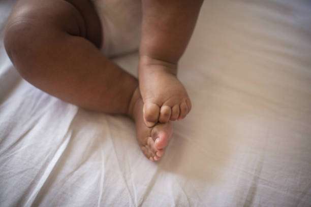 Tiny toes. Little baby on bed.