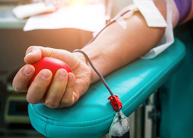 Blood donor at donation with bouncy ball holding in hand