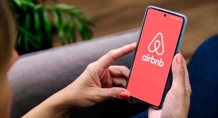 Woman,Holding,A,Mobile,Phone,With,Airbnb,App,On,The